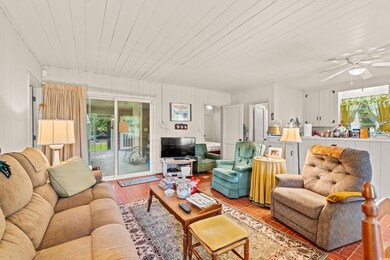 Living room featuring plenty of natural light, ceiling fan, and wooden ceiling