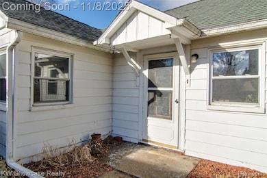 Doorway to property featuring roof with shingles and a patio