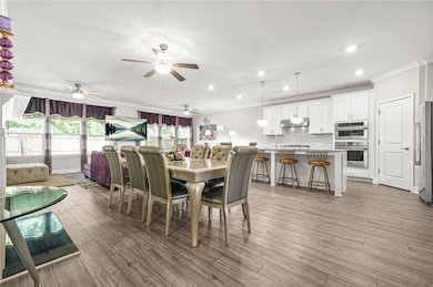 Dining room featuring crown molding, light wood-style flooring, recessed lighting, and ceiling fan