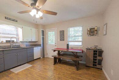 Kitchen with dishwasher, ceiling fan, wood finished floors, gray cabinets, and white cabinetry