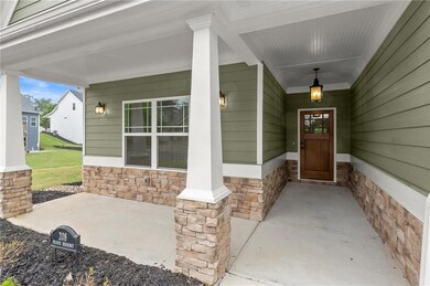 Entrance to property featuring stone siding and a porch
