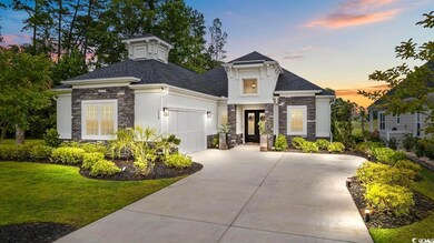 View of front facade with stone siding, driveway, a garage, stucco siding, and a lawn