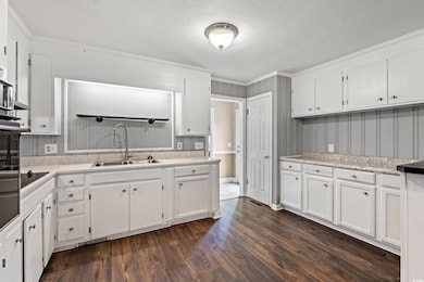 Kitchen with white cabinets, light countertops, da