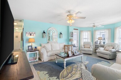 Living room featuring wood finished floors, a ceiling fan, healthy amount of natural light, and a textured ceiling