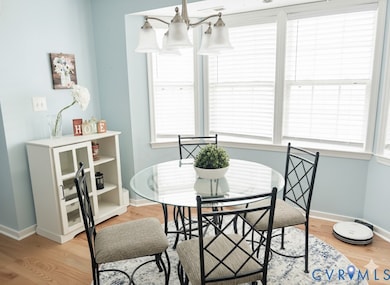 Dining area with plenty of natural light, light hardwood flooring, and a chandelier