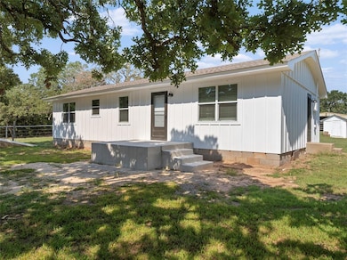 Rear view of property featuring a lawn and roof with shingles