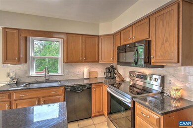 Large kitchen filled with light and glass slider access to expansive deck.  Perfect for entertaining. Beautiful new granite counter top & island complimented by tile backsplash.