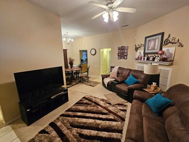 Living room with light carpet and ceiling fan with