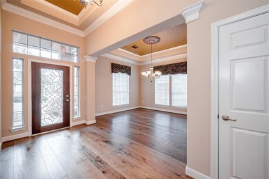 Updates include hardwood flooring throughout main living areas, new glass in front door, upgraded lighting, crown moulding, and decorative finishes throughout.
