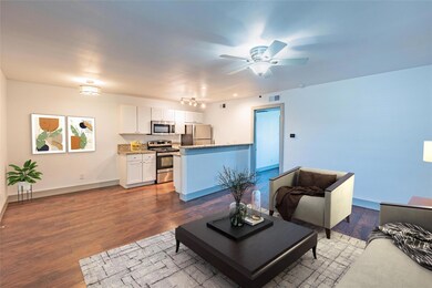 Living room featuring ceiling fan and dark hardwoo