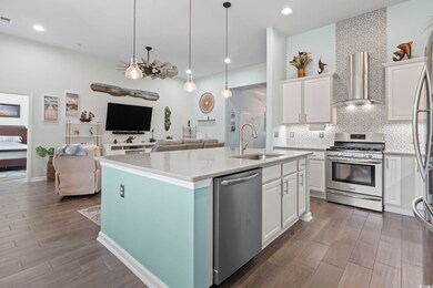 Kitchen with sink, white cabinetry, wall chimney e