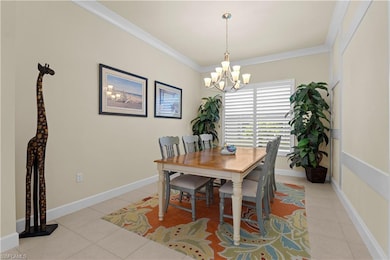 Dining area featuring light tile patterned floors, ornamental molding, and a chandelier