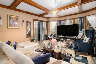 Carpeted living room featuring beam ceiling and coffered ceiling