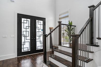 Foyer with wood finished floors, stairway, a high 