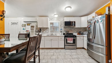 Kitchen with stainless steel appliances, white cabinets, light countertops, tasteful backsplash, and a textured ceiling