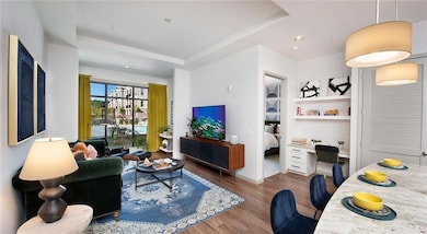 Living room with a tray ceiling and wood-type floo