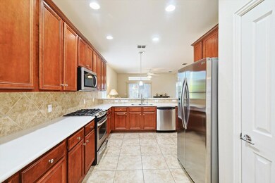 Kitchen with ceiling fan, backsplash, appliances w