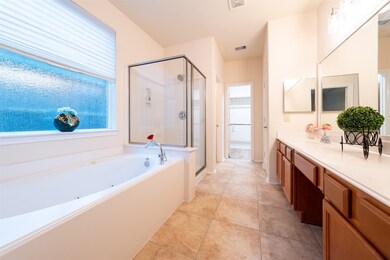 This primary bathroom offers large soaking tub, gl