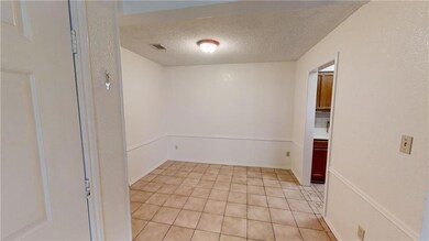 Unfurnished room with a textured ceiling and ligh