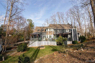 Rear view of property featuring stairway, a lawn,