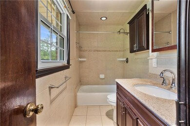 Bathroom with vanity, tile walls, tile patterned flooring, shower / bathtub combination, and recessed lighting