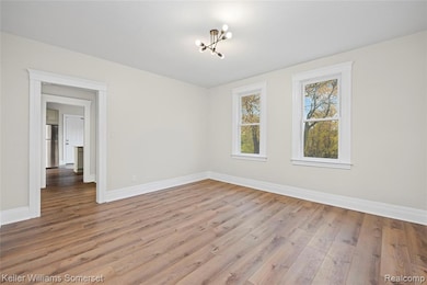 Unfurnished room featuring light wood-type flooring and a chandelier