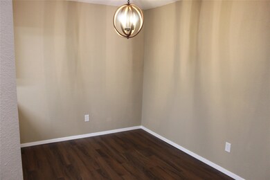 The Dining Room features an updated light fixture, vinyl wood flooring and neutral paint. Located just off the Living Area & Kitchen.