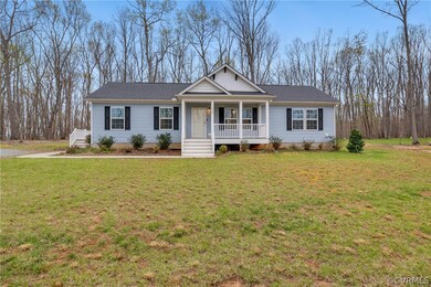 Ranch-style house with covered porch and a front y