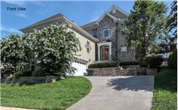 View of home from the street.  A gently winding drive goes to the attached two-car garage.