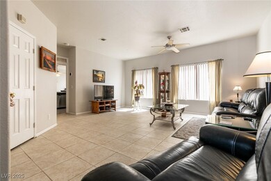 Living room with a ceiling fan and light tile patt