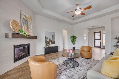 Living area featuring ceiling fan, arched walkway