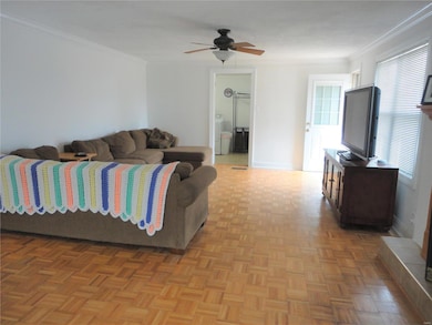 Living room with door leading to deck and back yard, door straight ahead is laundry room and leads to garage