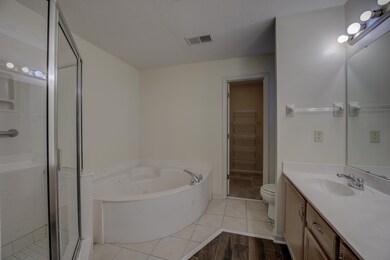 Full bathroom with vanity, toilet, a textured ceil