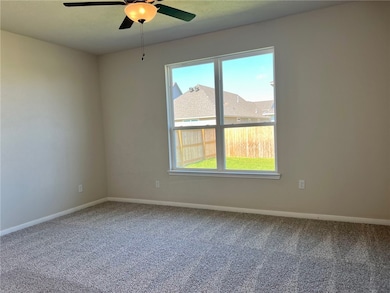 Carpeted primary bedroom with natural light and a
