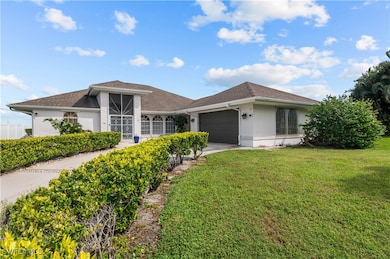Single story home with a garage and a front yard