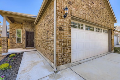 Doorway to property with brick siding, a garage, a porch, and concrete driveway