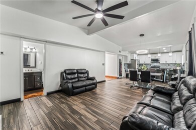 Living room with a ceiling fan and dark wood-style