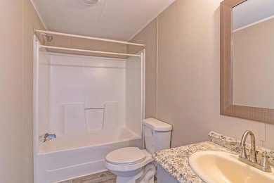 Full bathroom featuring a textured ceiling, vanity