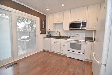 Remodeled kitchen with hardwoods and blinds-in-gla