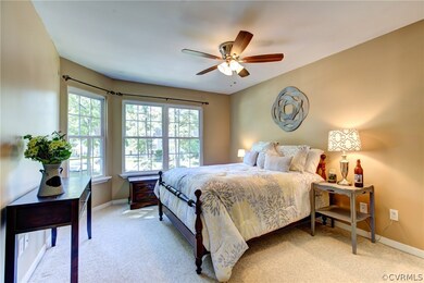 Master bedroom with ceiling fan and en suite master bathroom