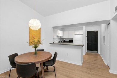 Dining room with light wood-style floors, a chandelier, baseboards, and high vaulted ceiling
