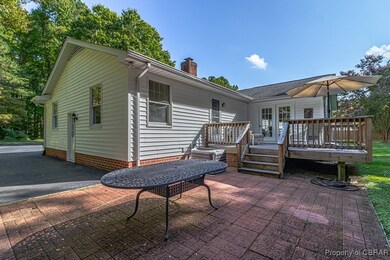 Rear view of house with a chimney, a deck, and a p