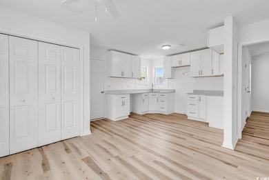 Kitchen featuring white cabinetry, a ceiling fan, 