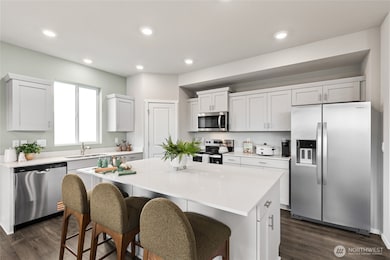 Modern kitchen with quartz countertops, soft close shaker style cabinetry, and stainless steel appliances. Photo is representational. Actual home is under construction. Colors, materials, and features may vary. See site agent for details.