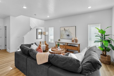 Living room featuring light wood-type flooring, healthy amount of natural light, recessed lighting, and stairs