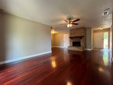 Unfurnished living room featuring ceiling fan, dar