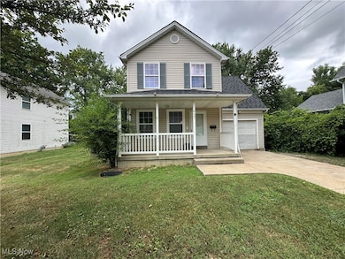 Traditional home with covered porch, driveway, a front lawn, a shingled roof, and an attached garage