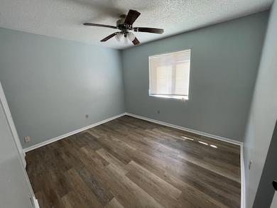 Unfurnished room with dark wood-type flooring, a 