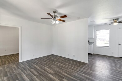 A clean, empty LIVING ROOM with wood flooring, whi