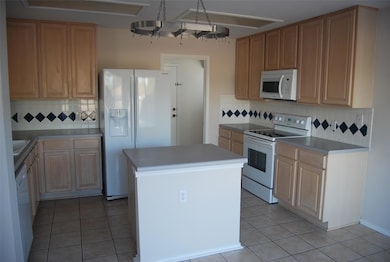 Kitchen featuring white appliances, backsplash, a